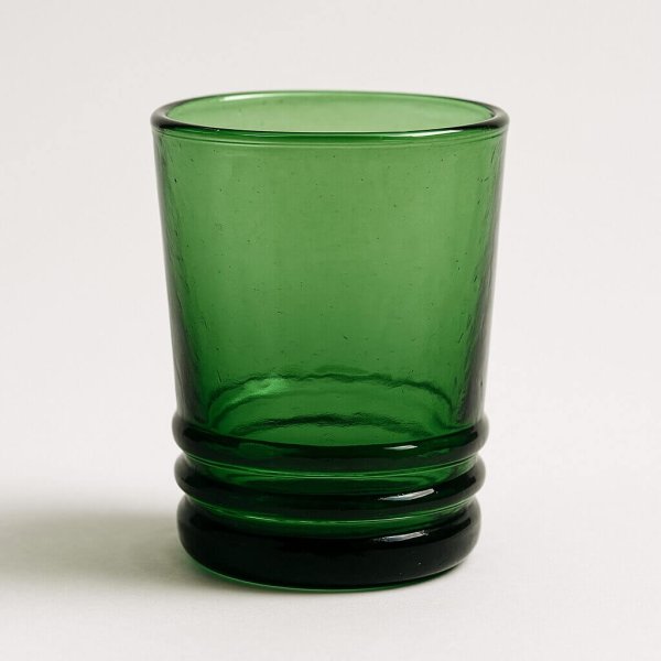 Close-up studio shot of single emerald recycled drinking glass.