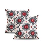 Pair of square Moroccan embroidered pillowcases with red and charcoal floral medallions on ivory cotton.