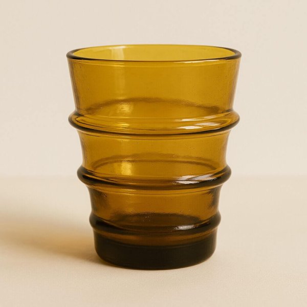 Studio close-up of a brown recycled glass tumbler with ribbed rings.