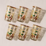 Top-down layout of six hand-painted Moroccan glasses casting patterned shadows.