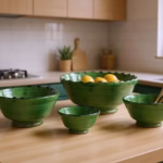 Three green Moroccan Tamegroute pottery bowls styled on small kitchen counter with fruits and utensils