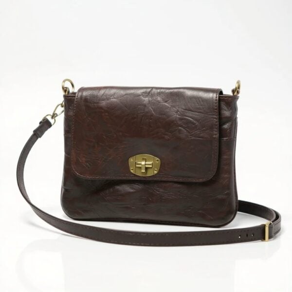 Dark brown leather crossbody bag with brass turnlock closure and adjustable strap on white background