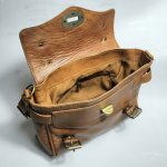 Interior view of vintage leather satchel bag showing spacious compartment, brass hardware and quality craftsmanship