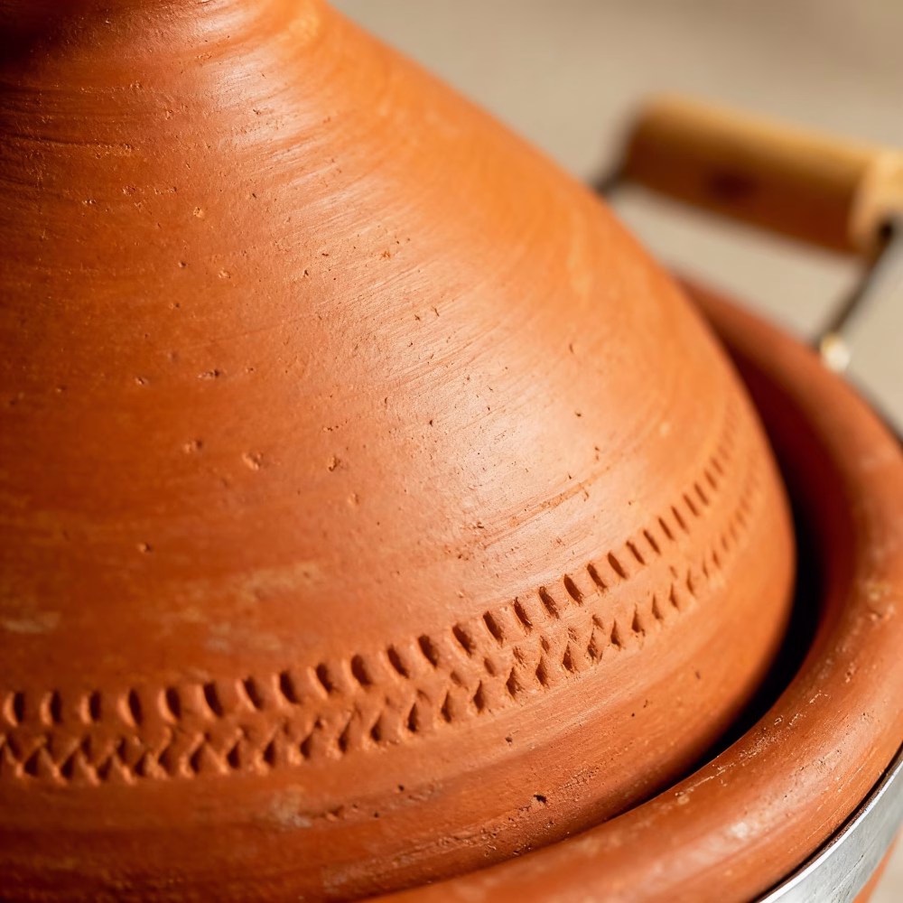 Detail view of hand-carved decorative pattern on natural terracotta tagine lid