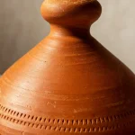 Close-up of terracotta tagine pot knob showing smooth clay texture and traditional craftsmanship
