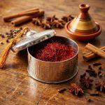 Silver hammered decorative box filled with saffron threads surrounded by whole spices