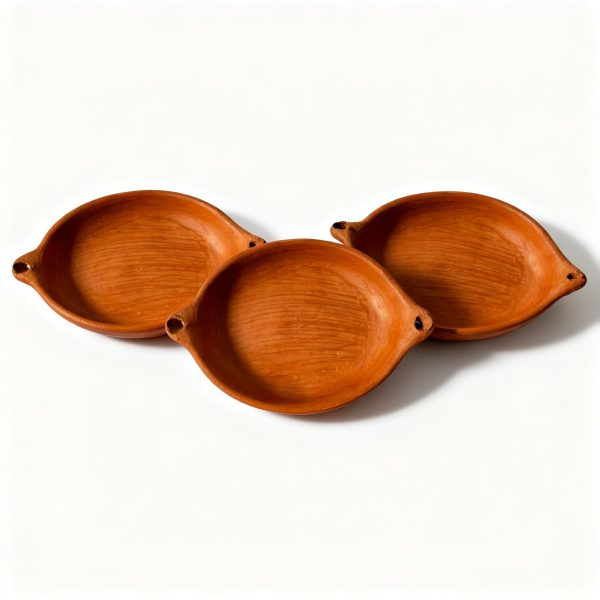 Set of three terracotta oval baking dishes arranged together showing identical handmade design