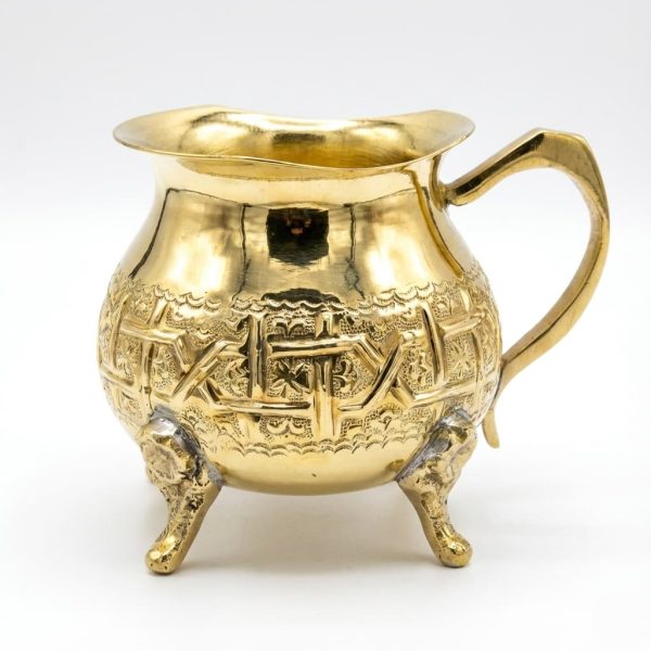 Hand-engraved brass gold mini creamer pitcher with traditional patterns and tripod feet