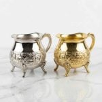 Hand-engraved mini creamer pitchers in silver and brass gold finish displayed on marble surface