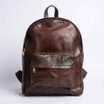 Dark brown Minimalist Leather Backpack front view on neutral gray background
