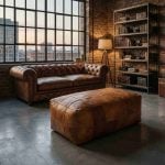 Large leather pouf bench paired with a Chesterfield sofa in an industrial loft setting.