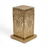 Single perforated brass table lamp showing intricate hand-engraved geometric and floral cutout patterns with warm interior glow