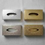 Four brass tissue box cover variations showing silver and gold finishes in hammered and engraved patterns