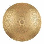 Round brass wall sconce with hand-pierced arabesque and floral medallion pattern illuminated showing warm golden glow on white background