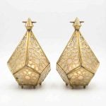 Pair of geometric brass candle lanterns with Islamic star patterns and frosted glass panels on white background