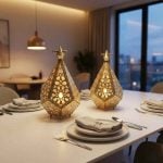 Two geometric brass tealight lanterns glowing warmly as dining table centerpiece in modern apartment at dusk
