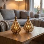Brass geometric candle holders on oak coffee table in cozy living room with gray sofa and knit throw blanket