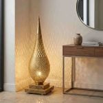 Brass floor lamp creating ambient lattice shadows in entryway beside walnut console table with round mirror and ceramic vase