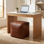 Leather cube ottoman used as desk seating in modern home office with natural wood furniture