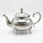 Full view of Silver Teapot with Diamond Pattern geometric engraving, curved spout, ornate handle, and decorative feet