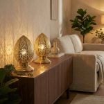 Brass filigree table lamps on modern credenza in contemporary living room casting intricate light patterns
