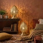 Brass filigree table lamps in bohemian living space creating warm ambient glow with decorative shadows