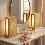 Pair of brass lantern table lamps on vanity table with gold mirror creating warm ambient glow in feminine dressing room