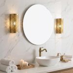Moroccan brass filigree wall sconce mounted in luxury marble bathroom beside round mirror
