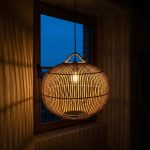 Rattan pendant light shade glowing warm at night – handwoven wicker ceiling lamp