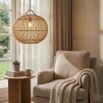 Rattan globe pendant lamp in a cosy living room beside an armchair and side table
