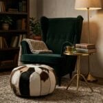 Hair-on-hide cowhide floor pouf beside green velvet armchair with brass side table and reading lamp