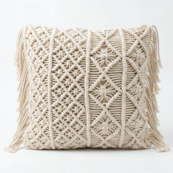 Cream macrame cushion cover featuring intricate diamond and leaf knotwork patterns with decorative side fringe tassels