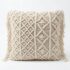 Cream macrame cushion cover featuring intricate diamond and leaf knotwork patterns with decorative side fringe tassels