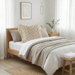 Macrame decorative pillow cover on oak bed frame in minimalist bedroom with neutral linen bedding and eucalyptus