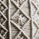 Close-up detail of hand-knotted cotton macrame showing square knot and gathering knot techniques in natural cream cord