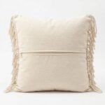Back of handwoven macrame cushion cover showing natural cotton canvas backing with concealed zipper closure and side fringe detail
