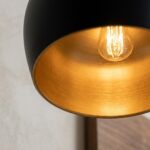 Close-up of the brushed gold brass interior and filament bulb of a black pendant light