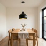Black brass teardrop pendant light centred over an oak dining table