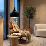 Matte black teardrop pendant lighting a reading chair by a window