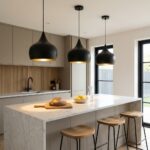 Three black teardrop pendant lights hanging over a marble kitchen island