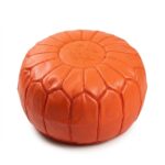 Orange leather pouf, round goatskin ottoman with tonal star embroidery on white background